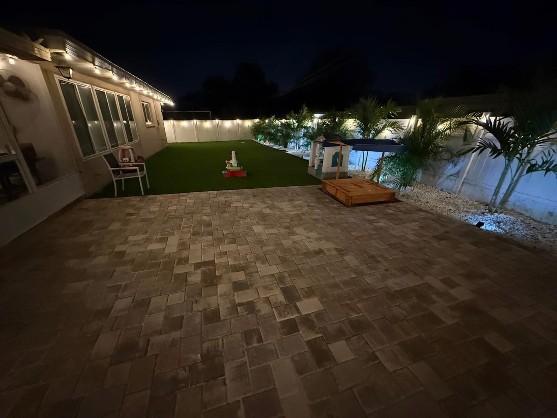 Backyard Oasis with Artificial Turf and Elegant Lighting